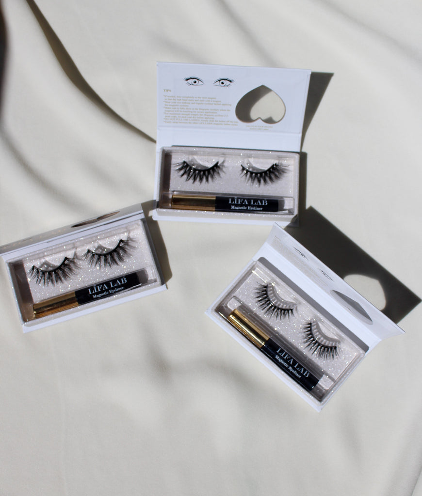Magnetic long salon eyelash from natural fibre with a magnetic black and gold eyeliner in three luxury boxes with a heart window on a white table cloth